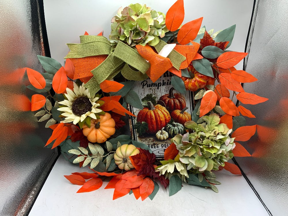 Autumn wreath with sunflowers, pumpkins, hydrangeas and orange leaves