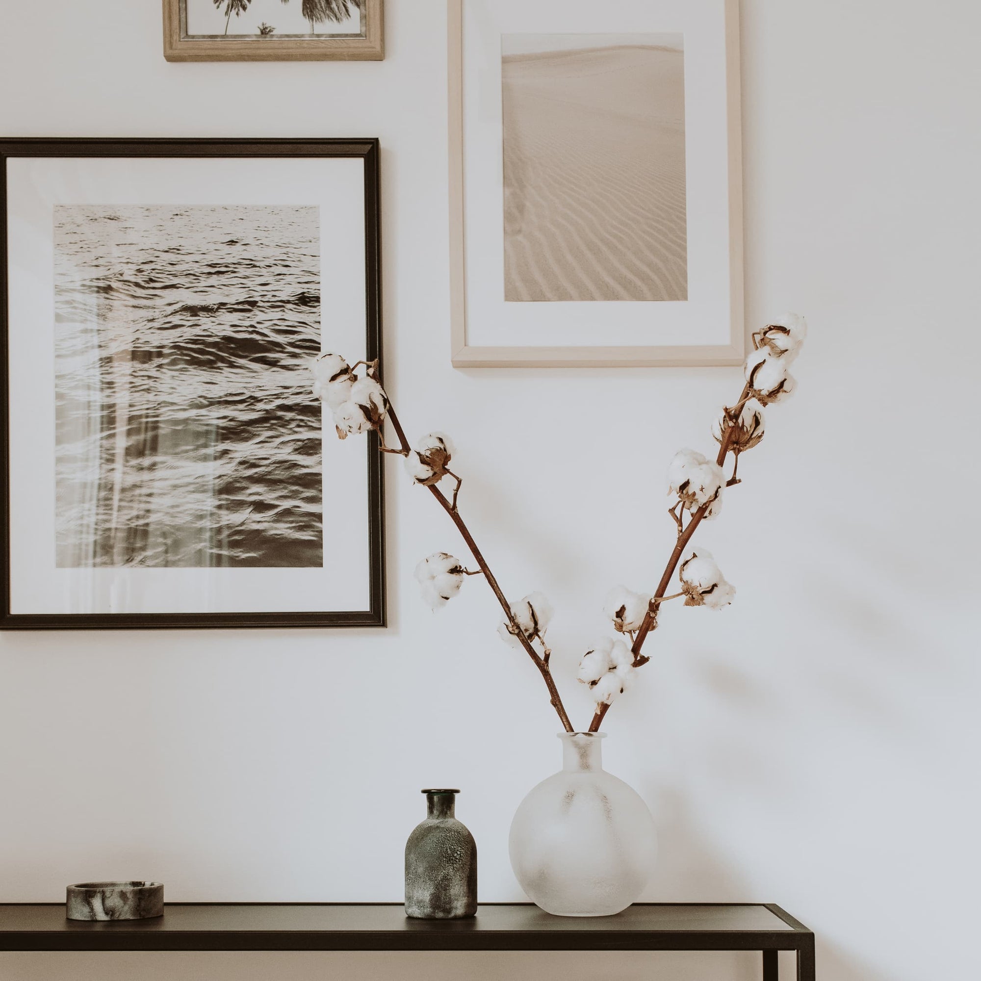 Home decor vignette with cotton stems and framed prints